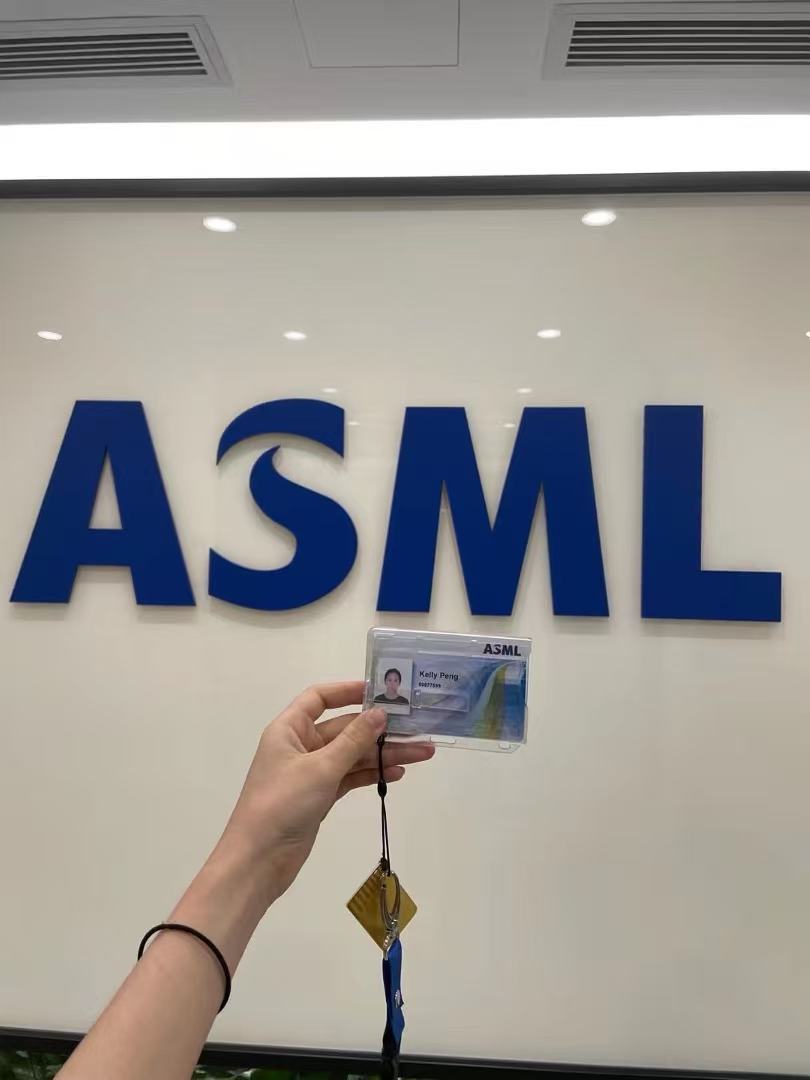 Kelly's ASML badge in front of the ASML wall logo